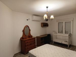 a bedroom with a bed and a mirror and a crib at El Hogar del Castañar - Alojamiento en El Tiemblo in El Tiemblo