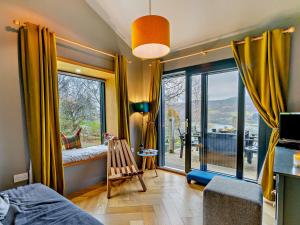 a bedroom with a large window with a view of a balcony at 3 Bed in Pitlochry CA207 in Struan
