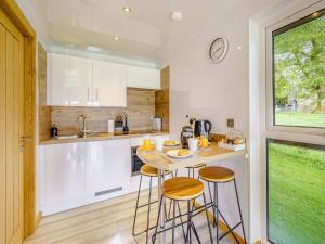 a kitchen with a table and two bar stools at 1 Bed in Keswick 82476 in Bassenthwaite