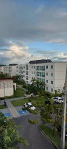 an apartment complex with cars parked in a parking lot at Palm Village Acqua in Porto De Galinhas