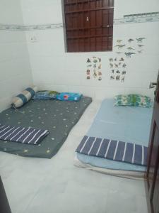 two beds sitting in a room with a wall at Hiwinwin Homestay Holiday in Chợ Phước Hải