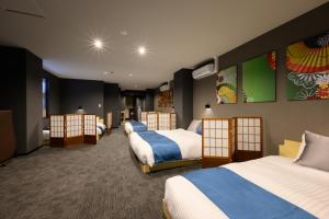 a hotel room with four beds in it at 廣島別邸 デラックススイート Hiroshima Villa for 10ppl - Supported by COCOSTAY in Hiroshima +62 photos