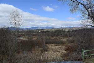 a bench in a field with mountains in the background at Pucker Street in Stowe