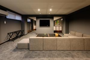 a living room with a couch and a tv at 廣島別邸 デラックススイート Hiroshima Villa for 10ppl - Supported by COCOSTAY in Hiroshima