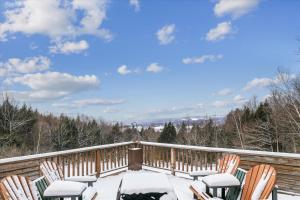 Una terraza cubierta de nieve con sillas encima. en Nine Hearths Estate, en Stowe