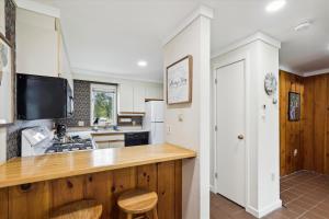 a kitchen with a counter with a sink and a tv at Village Green 10C in Stowe