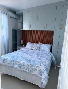 a bedroom with a bed with a blue and white comforter at Elegante casa a minutos de Centro comercial in San Miguel +4 photos