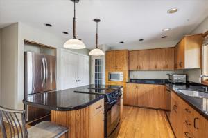 Una cocina con gabinetes de madera y un refrigerador de acero inoxidable. en Pinnacle Lookout, en Stowe