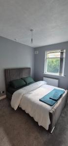 ブラッドフォードにあるCosy Stay Near Arena & Leeds Bradford Airport two bedroom Houseの大きなベッドと窓のある寝室