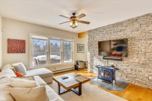 a living room with a brick wall and a tv at The Eagle's Nest at Stowe in Stowe