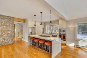 a kitchen with a large island with bar stools at The Eagle's Nest at Stowe in Stowe +32 photos