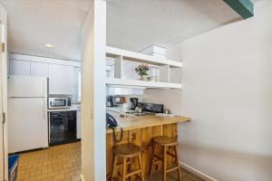 Una cocina con encimera y taburetes en una habitación. en Village Green 8D, en Stowe