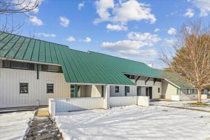 un gran edificio blanco con techo verde en Village Green 8D, en Stowe