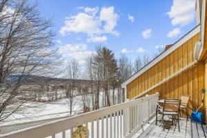 a balcony of a house with a view of the snow at Mountainside Condo J201 in Stowe