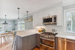 a kitchen with white cabinets and a stove top oven at Village Sunrise in Stowe