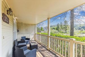a balcony with chairs and a view of the mountains at Village Sunrise in Stowe