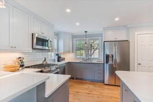 a kitchen with white cabinets and a stainless steel refrigerator at Village Sunrise in Stowe +22 photos