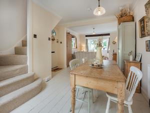 a dining room with a wooden table and white chairs at Greenfield Cottage 1866 in Broadwater