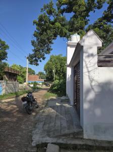 una motocicleta estacionada al lado de un edificio blanco en Lodhi Home stay, en Kākori