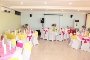 a banquet hall with tables and chairs with bows at Hotel Le Marly in Abidjan +120 photos