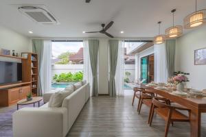 a living room with a couch and a dining room table at V226 4BR Pool Villa Near Laguna, Golf & Beaches in Laguna Phuket