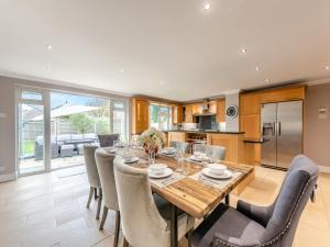 a kitchen and dining room with a wooden table and chairs at Marine Villa in Goring by Sea