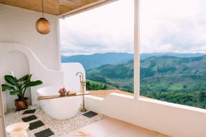 a bathroom with a tub and a view of mountains at Nontawa Villa Doichang in Ban Huai Khai