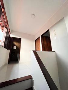 a staircase in a house with white walls at Casa Perto da Praia - Barra de São Miguel in Barra de São Miguel