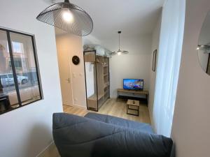 ベルフォールにあるLogement Neuf Cosy avec Espaces Communs Premium 04の青いソファとテレビのあるリビングルーム +22枚の写真