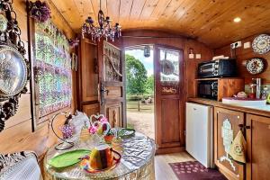 a kitchen with a table in a room at Roulotte la comtesse gitane in Plescop