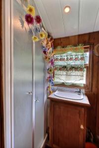 a bathroom with a shower with flowers on the ceiling at Roulotte la comtesse gitane in Plescop