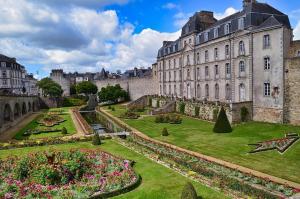 a large building with a garden in front of it at Roulotte la comtesse gitane in Plescop