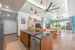 una cucina con bancone e una sala da pranzo di V227 Private 4BR Pool Villa Beaches & Golf Nearby a Laguna Phuket