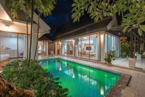 una piscina al centro di una casa di V227 Private 4BR Pool Villa Beaches & Golf Nearby a Laguna Phuket
