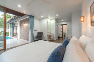 una camera da letto con un grande letto bianco e una scrivania di V227 Private 4BR Pool Villa Beaches & Golf Nearby a Laguna Phuket Altre 51 foto