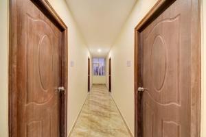 a corridor with two wooden doors and a hallway at Hotel O JV Colony Near KFC Gachibowli in Hyderabad