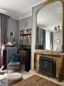 オーボンヌにあるVilla La Marquise de la Chesnaie à 15 mn de Parisのリビングルーム(鏡、暖炉付)