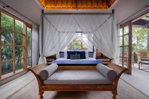une chambre avec un lit dans une pièce avec des fenêtres dans l'établissement Villa Maya Scenic in Canggu, à Dalung