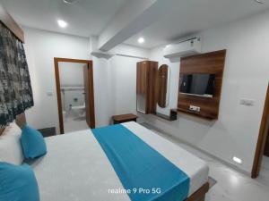 a bedroom with a bed and a tv on the wall at Hotel Haveli in Ahmedabad
