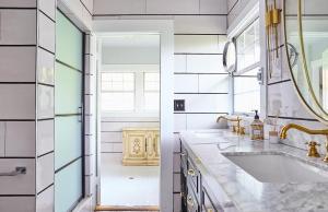 Un baño blanco con lavabo y espejo. en The Hollywood Homestay, en Los Ángeles