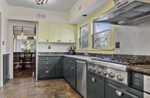 cocina con armarios grises y horno con fogones en The Hollywood Homestay, en Los Ángeles