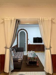 a living room with curtains and a couch and a table at The Market House in Da Lat