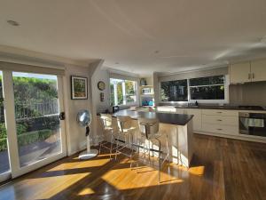 a kitchen with a island with bar stools at Fenway Cottage in Bowral