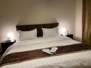 a large bed with a pair of shoes on it at شقه ليالي المارينا اطلاله بحريه عوائل in King Abdullah Economic City