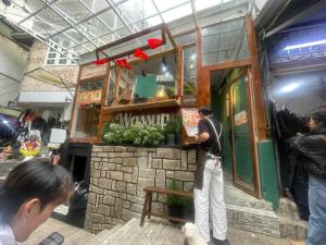 a man standing in front of a food stand at The Market House in Da Lat