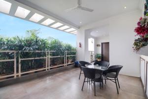 a dining room with a table and chairs and plants at Hotel O SUN CITY in Vijayawada