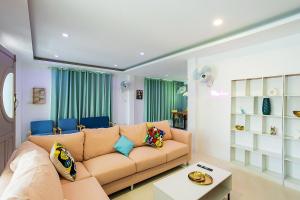 a living room with a brown couch and blue chairs at V228 Renovated 3BR Pool Villa Near Top Beaches in Bang Rak Beach
