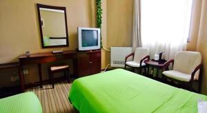 a hotel room with a bed and a mirror and a tv at Super 8 Hotel Xian Nanshaomen in Xi'an
