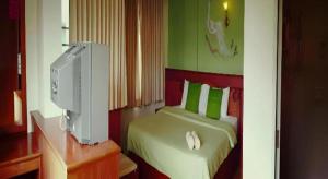 a bedroom with a bed with a computer on a desk at Loei Orchid Hotel in Loei