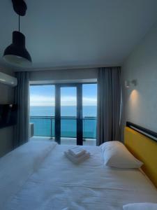 a bedroom with a large bed with a large window at Beach Tower 33 floor, 3301 in Batumi